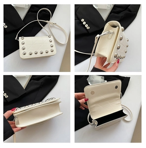 Dettaglio borsa crema con borchie argento e layout dello scomparto interno