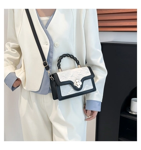 Detail of star-embossed contrast handbag featuring rope handle and clover clasp