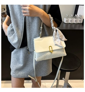Dettaglio borsa in pelle intrecciata bianca con foulard al manico e fibbia dorata