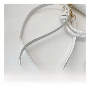 Détail de la bandoulière tissée blanche avec boucles et anneau en métal doré chic