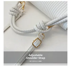 Détail du sac tressé blanc avec boucle dorée et bandoulière à nœuds ajustable