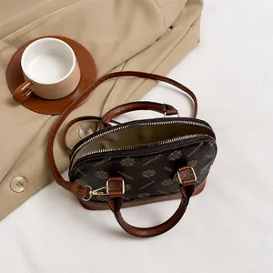 Draufsicht auf die offene Muscheltasche mit Vintage-Druck und geräumigem Innenfach