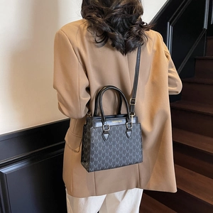 Sac fourre-tout tendance avec imprimé monogramme M et poignées sur un mannequin chic