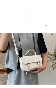 Detail of off-white lychee pattern leather bag featuring dual-strap flap and soft texture