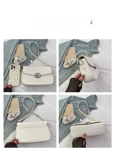 Detail view of white pebbled leather saddle bag with square metal buckle and chain strap