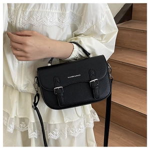 Detail of black lychee grain saddle bag with silver buckles and hand strap