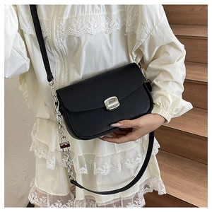 Close-up of black lychee grain leather saddle bag featuring a square silver metal lock