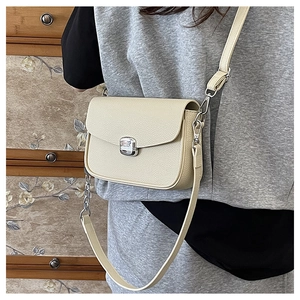 Detail of cream saddle bag with lychee texture leather and silver square swivel lock