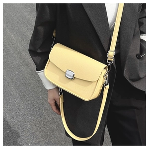 Close-up of bright yellow saddle bag with silver buckle worn on a grey blazer