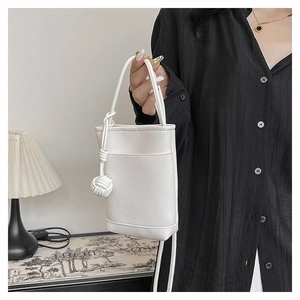 Détail du mini sac seau blanc à motif litchi avec nœud en corde tissée décoratif