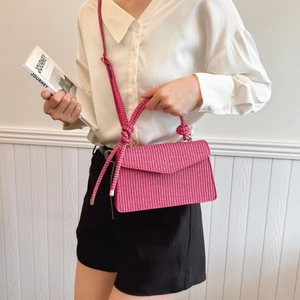 Sac à main rose fuchsia tressé avec bandoulière à nœuds, porté épaule et croisé d'été