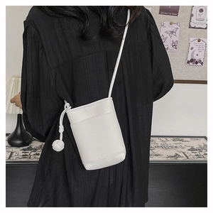 Mini sac pour téléphone en cuir litchi blanc avec détail de nœud sur un mannequin