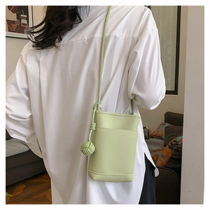 Détail du mini sac bandoulière vert avocat avec texture litchi et bandoulière nouée
