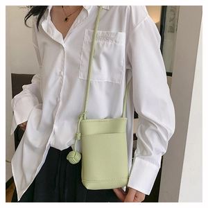 Détail du sac de téléphone vert clair en cuir grainé avec sangle nouée et poche avant