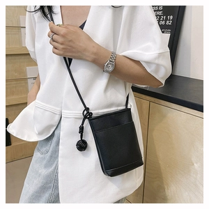 Détail d'un mini sac bandoulière en cuir noir avec bandoulière en corde sur un mannequin