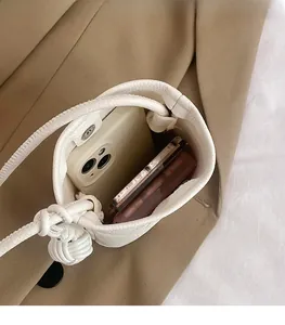 Vue de dessus du mini sac seau blanc grainé montrant l'espace pour le téléphone