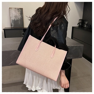 Detailed texture of pink woven tote bag featuring large capacity and premium leather straps