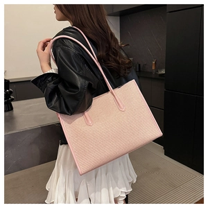 Detail of pink woven texture on large tote bag shown on model for size perspective