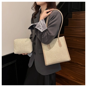 Detail of beige woven tote bag set with matching small zipper pouch on wooden stairs