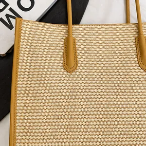 Close-up of woven straw tote bag with bright yellow leather trim and precise stitching