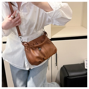 Brown litchi leather crossbody bag with pleated cloud design and adjustable strap