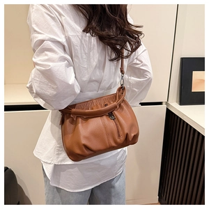 Brown lychee grain leather bucket bag featuring pleated drawstring closure and ring handles