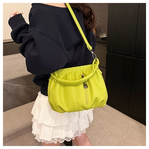 Detailed side view of neon green pleated cloud bucket bag with textured leather and zipper