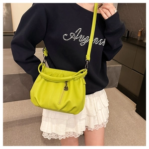 Detail of neon green lychee pattern crossbody bag with pleated bottom and front zipper