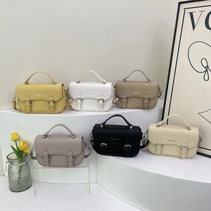 Chic saddle crossbody bags in various colors displayed on stylish minimalist pedestals
