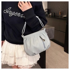 Detail of light blue lychee pattern bucket bag with pleated opening and metal zipper