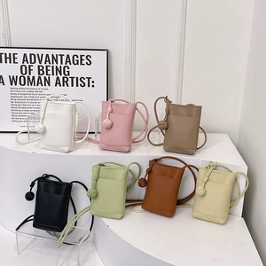 Mini sacs à bandoulière en cuir texturé en sept couleurs sur des marches blanches