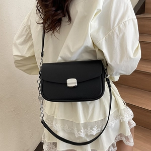 Classic black litchi pattern saddle bag with silver metal buckle and chain strap on model