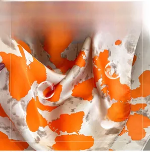 Close-up of orange and white silk scarf showing breathable and skin-friendly texture