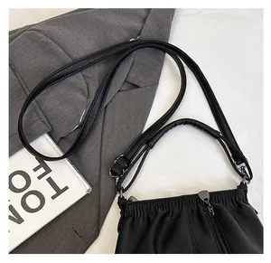Detail of black lychee grain leather bucket bag with pleated texture and dual strap design