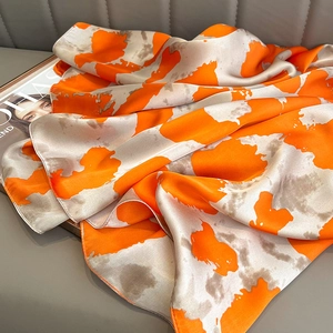 Silk-like satin scarf in orange and beige abstract patterns for sun protection