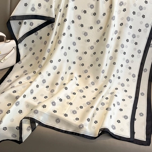 Close-up of elegant camellia flower pattern on silk shawl with black border detailing