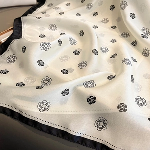 Detail shot of the 100% silk fabric with elegant black camellia floral print