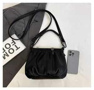 Detail of black lychee grain leather bucket bag with pleats and silver-tone hardware