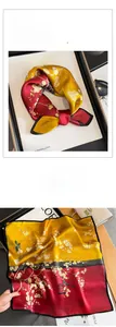 Detailed view of luxury silk scarf with plum blossoms and bird pattern in red and yellow