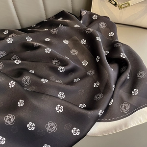 Detailed view of the soft silk-like fabric texture with white camellia flower print