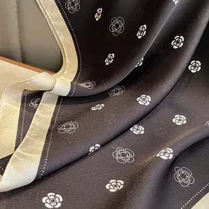 Detailed view of camellia floral print silk scarf with refined contrast border textures
