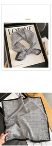Détail d'un foulard en soie vintage avec imprimé abstrait noir et blanc sur magazine