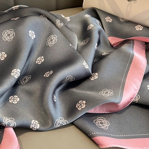 Detailed view of silk-like camellia print scarf with pink edges and floral pattern