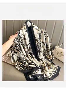 Detail of silk leopard print scarf with black borders and smooth glossy finish