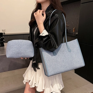 Blue woven tote bag set with matching pouch and stylish leather handles on model