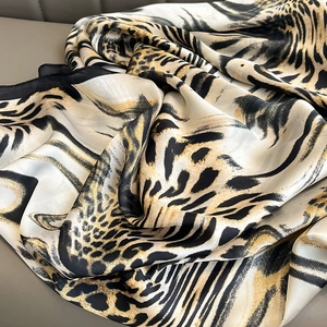 Elegant leopard and zebra print silk scarf in beige, displayed with soft luxury texture