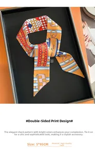 Detail of orange checkered silk scarf with chain pattern on a chic display tray
