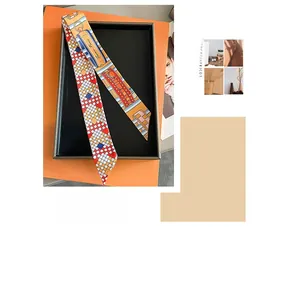 Close-up of printed silk twilly scarf featuring Paris architecture in a gift box