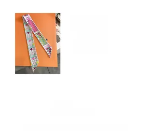 Detail of colorful geometric plaid twilly scarf on orange box with digital printing
