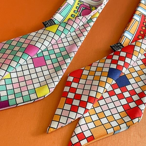 Detailed macro view of checkered twilly scarves and 100% polyester fabric care label